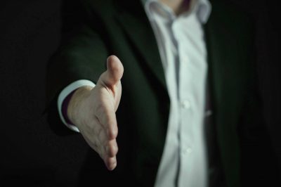 Handschlag zur Begrüßung – Networking & Empfang Mann im Anzug streckt die Hand zum Handschlag aus – freundliche Begrüßung bei Konferenzen, Empfang und Schulungen